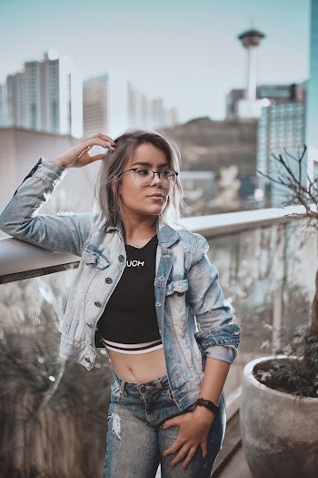 Woman Wearing Blue Denim Jacket Leaning on Stainless Steel Rail