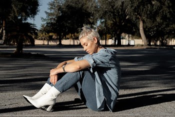 Woman Wearing Blue Denim Jacket Sitting on Ground