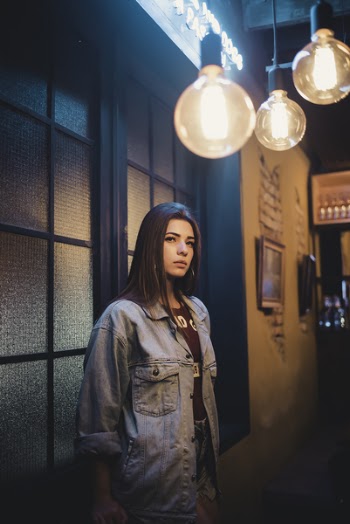 Woman Wearing Blue Denim Jacket Standing Beside Window