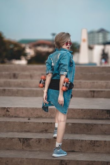 woman wearing blue denim jacket walking on stair at daytime