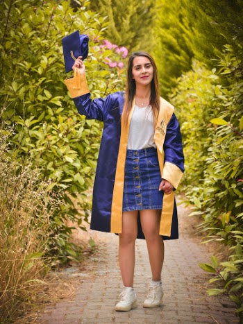 Woman Wearing Blue Graduation Gown raising Graduation Cap