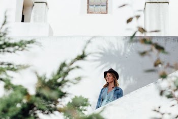 woman wearing blue jacket and black hat standing on stairs