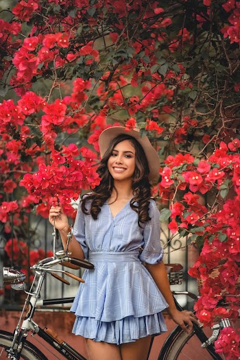 Woman Wearing Blue Mini Dress Standing Under A Flowers Bearing Tree