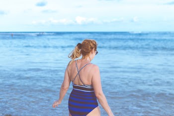 Woman Wearing Blue Monokini Standing Beside Body Of Water Under Blue Sky