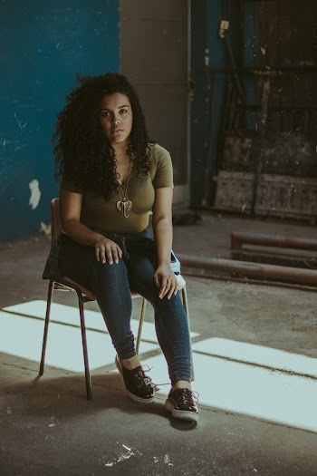 Woman Wearing Blue Skinny Jeans Sitting On Chair