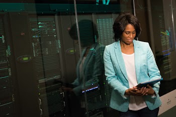 Woman Wearing Blue Suit Jacket Standing Near Glass Wall