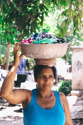 Woman Wearing Blue Tank Top Carrying Basin
