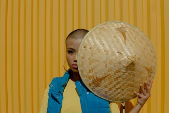 Woman Wearing Blue Vest Holding Brown Wicker Hat
