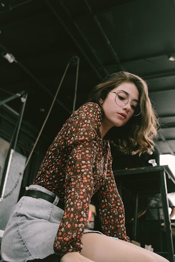 Woman Wearing Brown and Pink Floral Long Sleeved Shirt With Denim Shorts