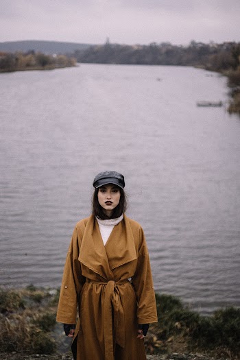 Woman Wearing Brown Coat Standing Near Body of Water