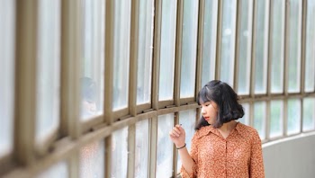 Woman Wearing Brown Dress Shirt While Sigh Seeing in Window