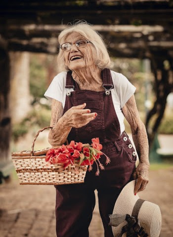 Woman Wearing Brown Dungaree Pants Holding Sunhat and Picnic Basket