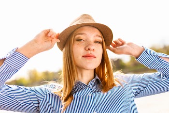 Woman Wearing Brown Hat and Blue Striped Dress Shirt