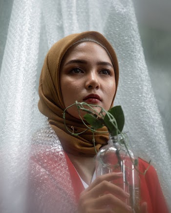 Woman Wearing Brown Headscarf Holding A Bottle