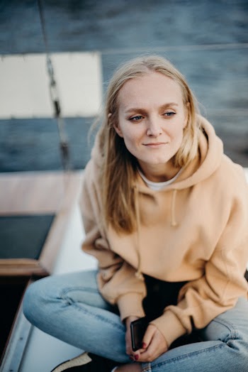 Woman Wearing Brown Hoodie and Blue Jeans