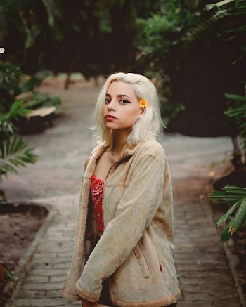 Woman Wearing Brown Jacket Standing Near Green Leaf Plants