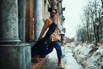 Woman Wearing Brown Jacket Stepping Outside on Snow Covered Pathway