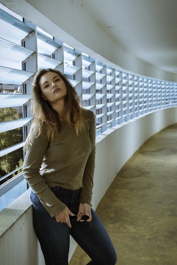 Woman Wearing Brown Long-sleeved Shirt While Leaning on Wall