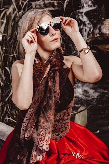 Woman Wearing Brown Sleeveless Top and Red Skirt While Wearing Sunglasses