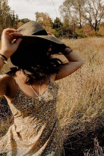 Woman Wearing Brown Spaghetti Strap Floral Dress Standing on Field