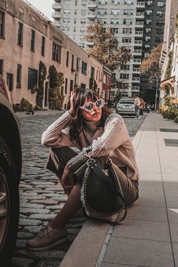 Woman Wearing Brown Turtleneck Sweater Sitting on Street
