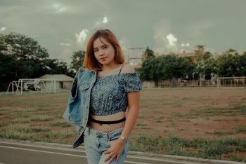 Woman Wearing Denim Jacket and Jeans Standing on Concrete Road