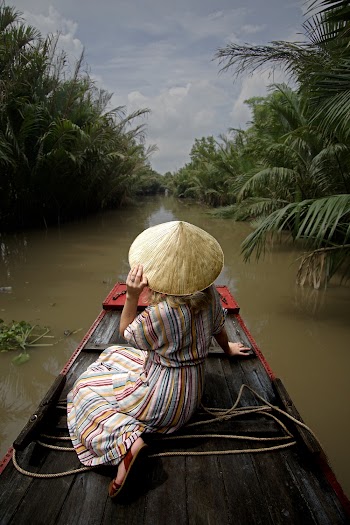 Woman Wearing Dress and Brown Hat Sitting on Boat