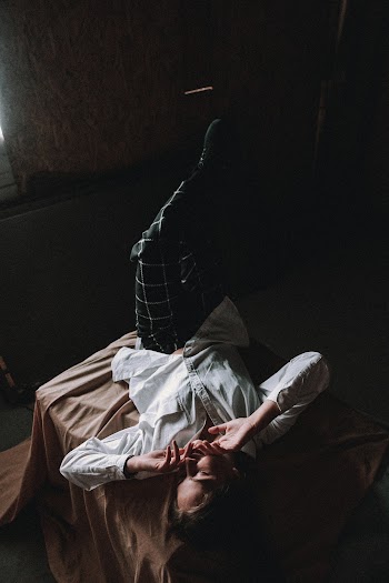 Woman Wearing Dress Shirt Lying on Bed
