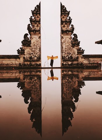 Woman Wearing Dress Standing Near Concrete Building With Reflection to Water