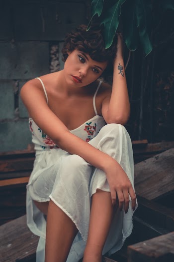 Woman Wearing Dress Touching Head With Left Hand