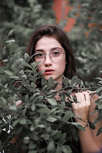 Woman Wearing Eyeglasses Behind Bushes