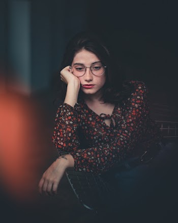 Woman Wearing Eyeglasses Leaning on Chair