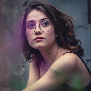 Woman Wearing Eyeglasses Near Gray Surface