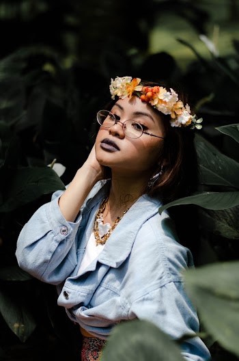Woman Wearing Eyeglasses Standing Beside Green Leaves
