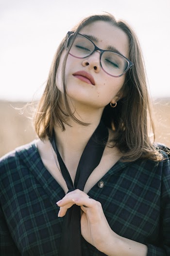 Woman Wearing Eyeglasses Touching Her Necktie