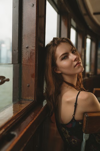 Woman Wearing Floral Spaghetti Strap Top Leaning Her Head on Wooden Window Frame