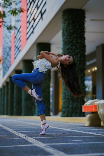 Woman wearing floral top and blue jeans posing on Street 