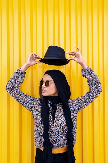 Woman Wearing Floral Top Holding Hat