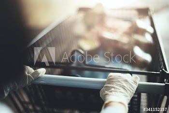 Woman wearing gloves to prevent coronavirus while using a shopping cart