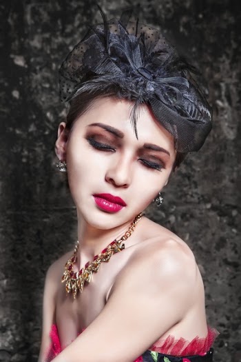 Woman Wearing Gold Necklace and Black Headdress Closing Her Eyes