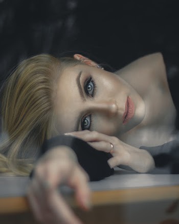 Woman Wearing Gold Ring lying on a table