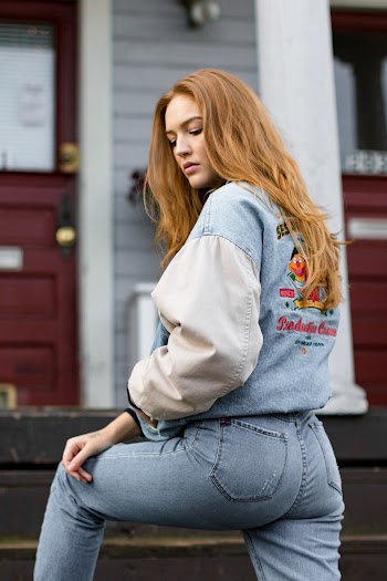 Woman Wearing Gray and Blue Jacket and Jeans Near the Red Door Closed Outdoor