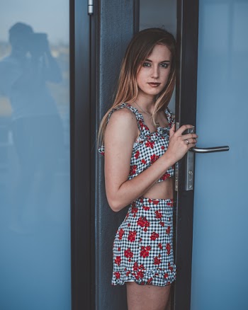 Woman Wearing Gray-and-red Floral Dress Standing Between Door