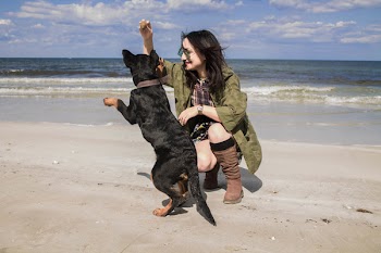 Woman Wearing Gray Coat Beside Black Dog