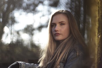Woman Wearing Gray Denim Jacket by the Wall