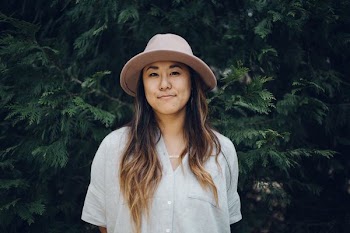 woman wearing gray dress shirt front of green trees