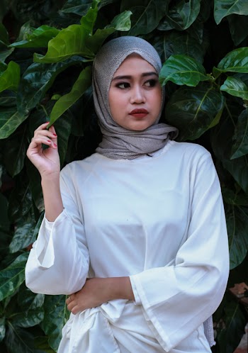 Woman Wearing Gray Headscarf Standing Near Plant