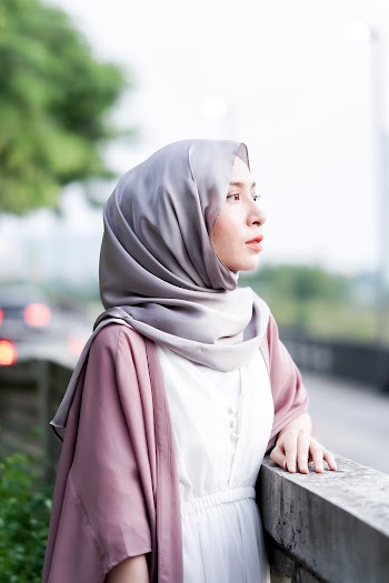 Woman Wearing Gray Hijab Standing Beside Concrete Frame