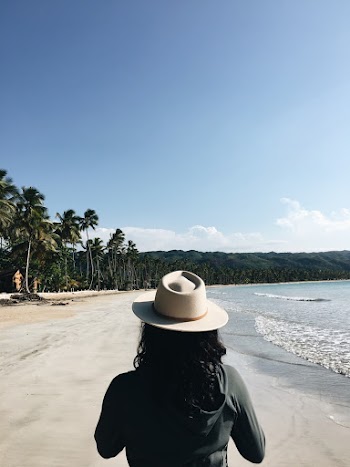 Woman Wearing Gray Jacket Walking on Seashore
