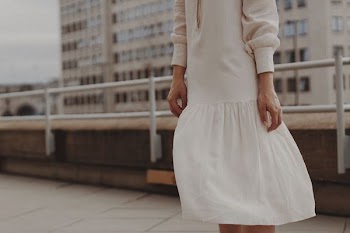 woman wearing gray long-sleeved dress standing near handrail